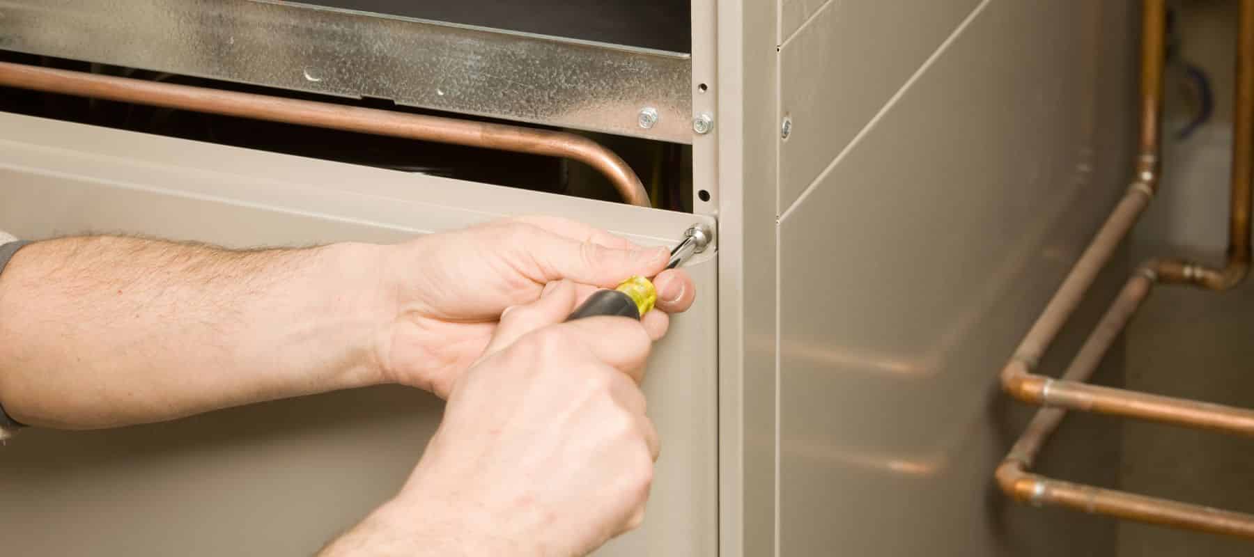 closeup of a hvac technician performing heater repairs on a residential furnace